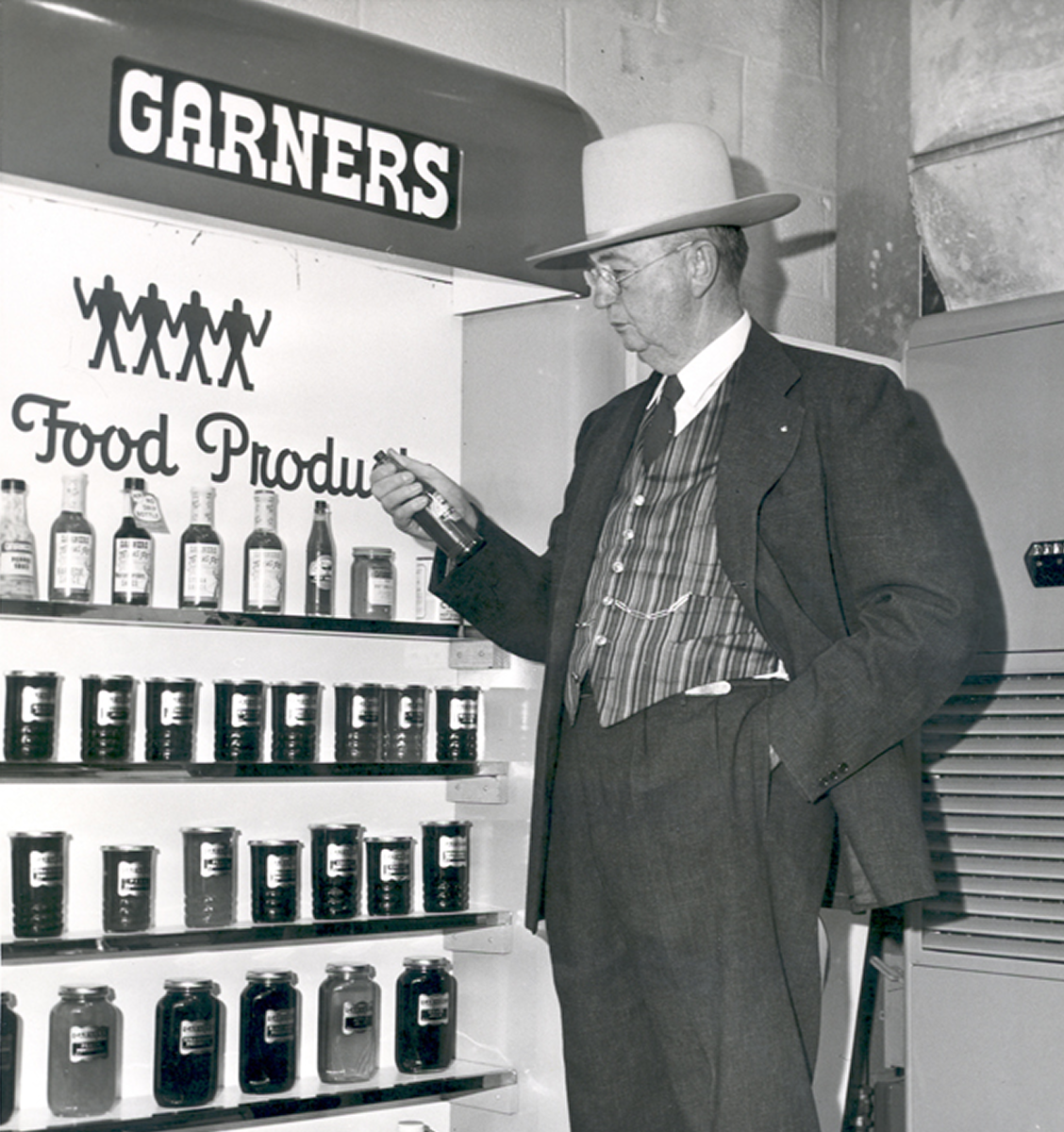 Founder Sam Garner standing next to a display of Garners Food Products.